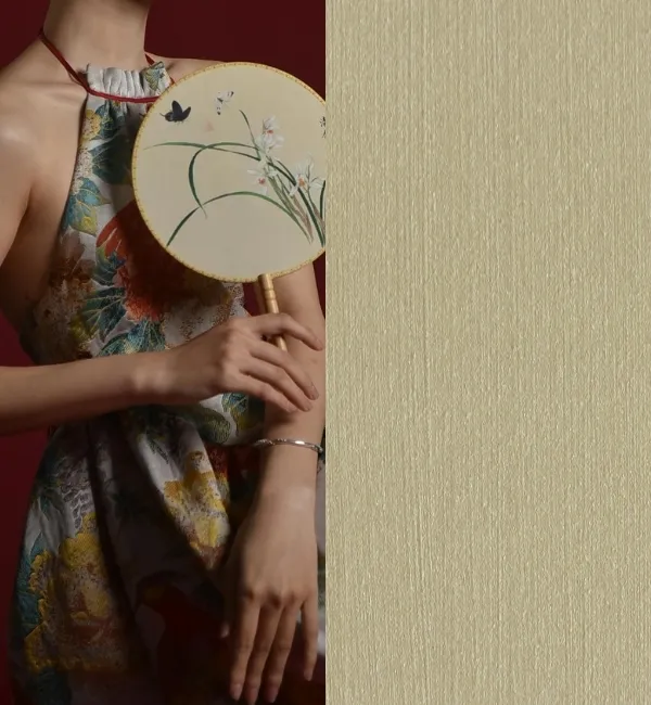 A person in a floral dress holds a fan with orchids and butterflies against a textured background.