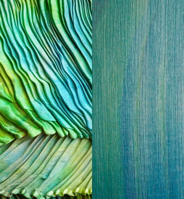 Pleated green and blue fabric contrasts with a textured teal surface.