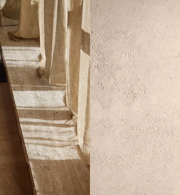Light filters through sheer curtains onto textured stone steps and a rough wall.