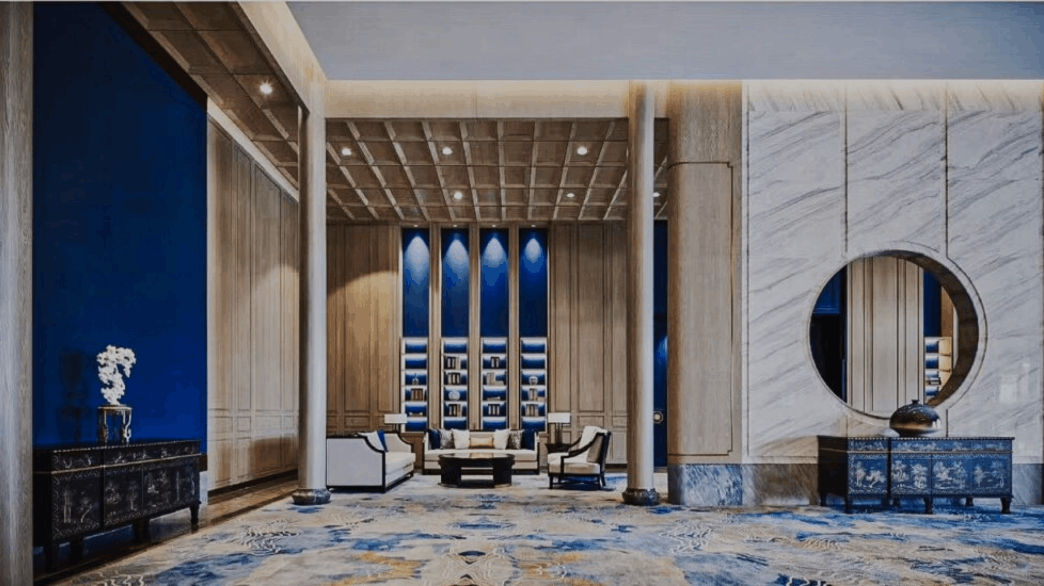High-end hospitality interior showcasing deep blue accent walls, warm wood paneling, and white marble finishes in a Chinese-contemporary lobby design