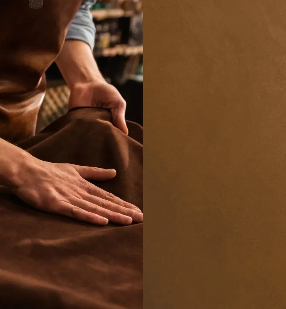 Hands smooth a rich brown suede fabric, suggesting a craftsman's touch.
