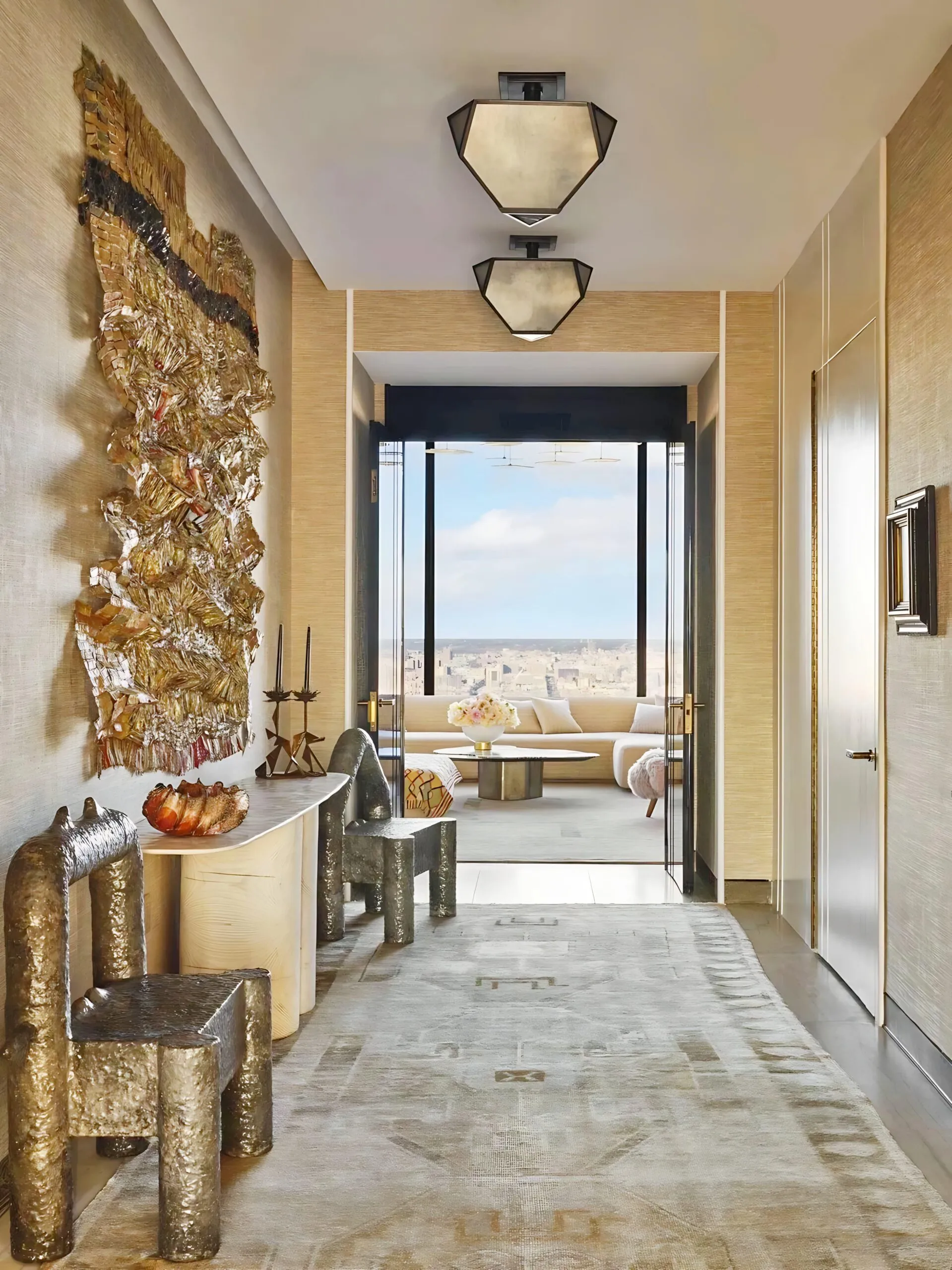 A modern hallway with abstract art, unique chairs, and a city view through a large window.