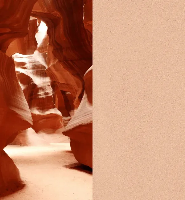 Sunlight streams into a narrow sandstone canyon with smooth, flowing walls.